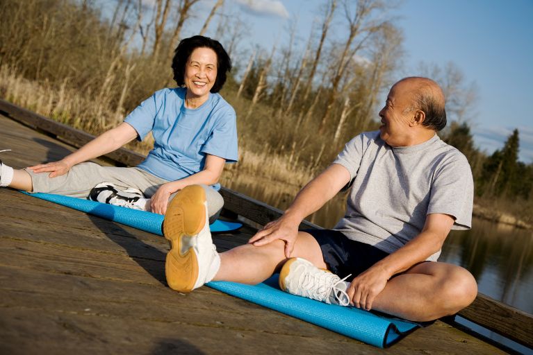 Older adults doing yoga together in the sunshine