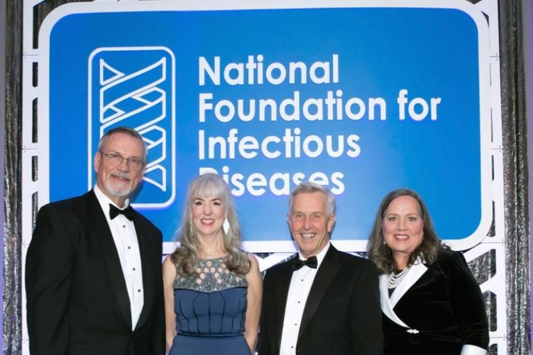 Group of individuals standing in front of an NFID banner