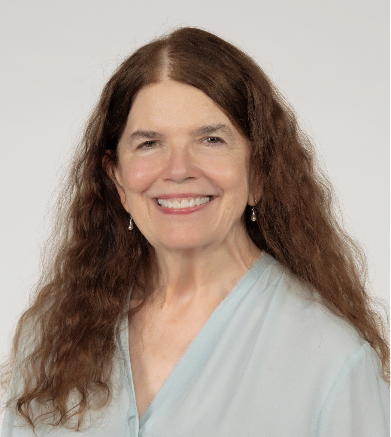 A woman with long brown hair smiles