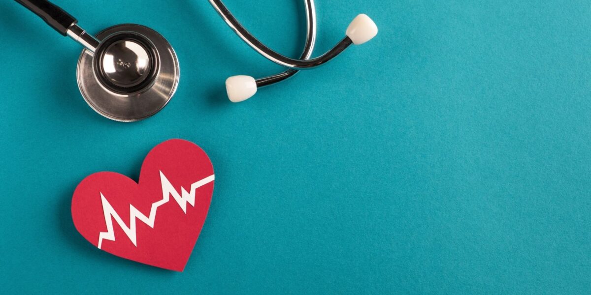 Red heart with a white heartbeat line next to a stethoscope on a teal background