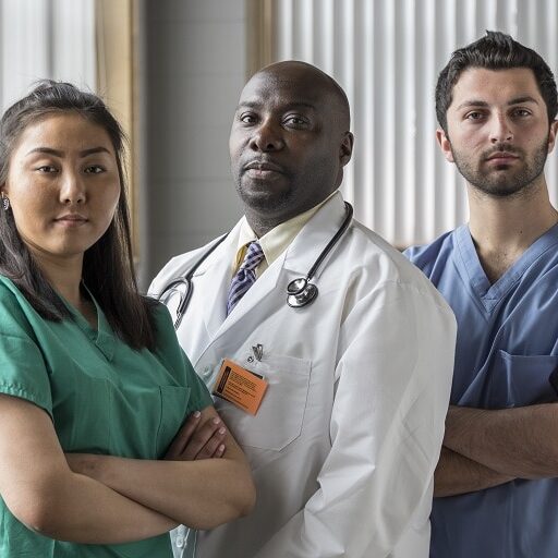 Young healthcare professionals in a medical setting, standing with their arms crossed