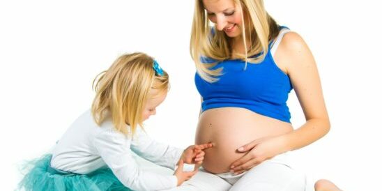 Pregnant woman with 2 zo daughter on white Pregnant woman with 2 zo daughter on white